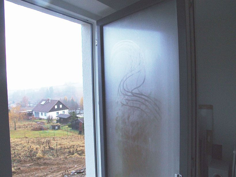 Hohe Luftfeuchtigkeit der Raumluft schlägt sich beim Öffnen gut gedämmter Fenster auf der Außenseite nieder Foto eines offenen Fensters, bei dem sich Kondensat auf der Außenseite der Scheibe bildet