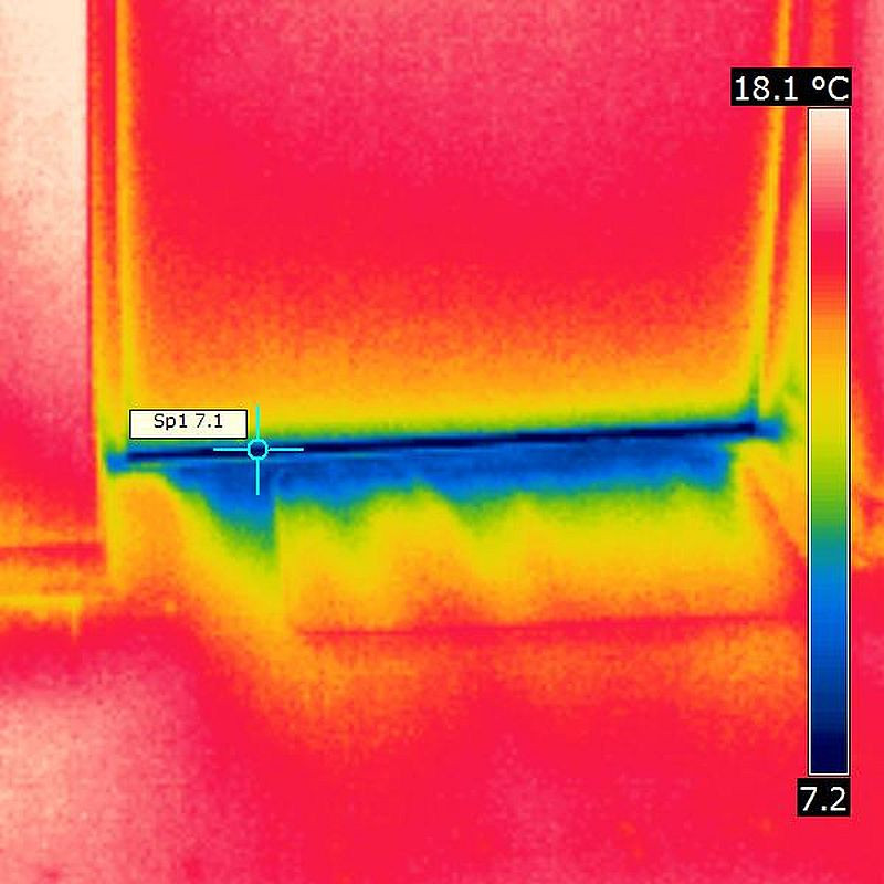Kalter Luftzug an undichter Wohnungstür Thermogramm einer Wohnungseingangstür zeigt kalten, unbehaglichen Luftzug am Boden