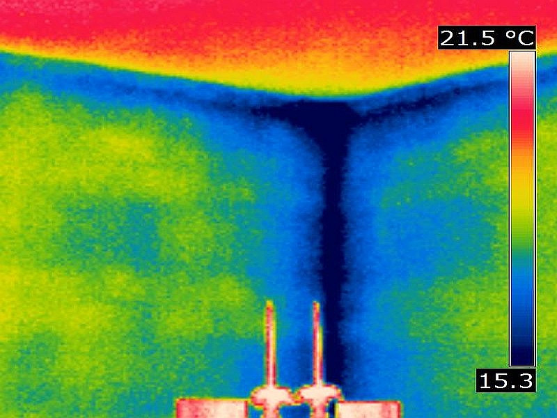 Obwohl die Lufttemperatur im Raum bei 21,5 °C liegt, bleibt es in der Raumecke bei 15,3 °C empfindlich kalt. Wärmebild einer Außenwandecke von innen zur Darstellung der Wärmebrücke