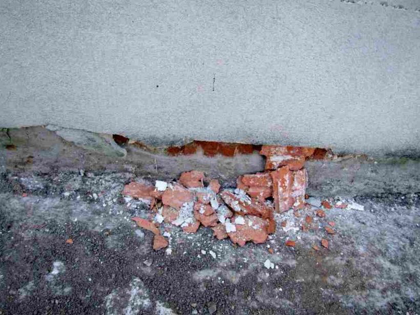 Abplatzungen des Putzes und der Ziegelsteine infolge Salzbelastung unterhalb der Horizontalsperre