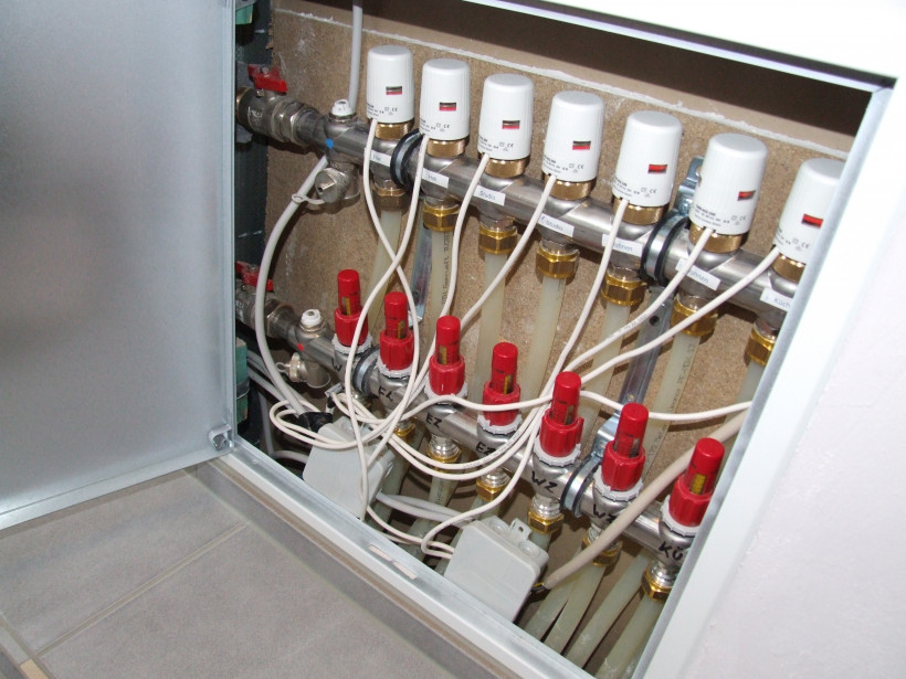 Verteilerschrank einer Fußbodenheizung  mit Stellantrieben - weiße Zylinder Verteilerschrank einer Fußbodenheizung (Etage) mit Stellantrieben (weiße Zylinder