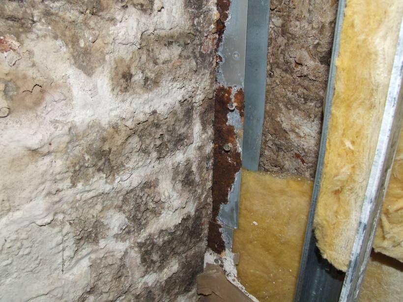 Schimmel auf einer Natursteinwand, verrostete Metallteile wegen Belüftungsmöglichkeit