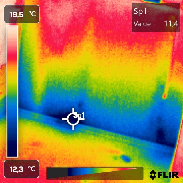 Kaltluft um 11°C strömt von unten am Rand einer Holzbalkendecke in den Wohnraum