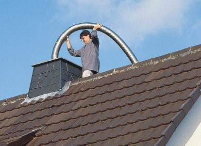 Einziehen eines speziellen Edelstahlwellrohres für die Abgasführung im alten Schornstein