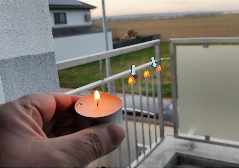 Die Kerzenflamme nahe der Innenseite der Verglasung zeigt 6, davon zwei rötliche Spiegelbilder